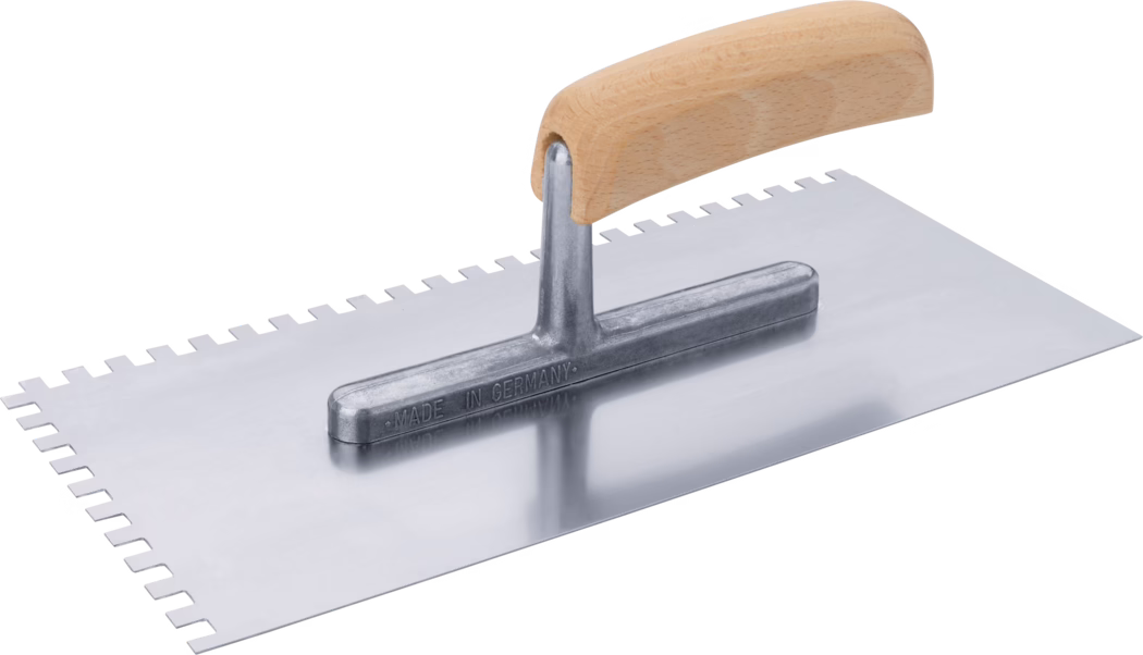 Rechteckige Zahnkelle mit polierter Metallplatte und gebogenem Holzgriff; eine lange Kante weist gleichmäßige quadratische Zähne auf und die Metallbefestigung ist mit „Made in Germany“ geprägt.
