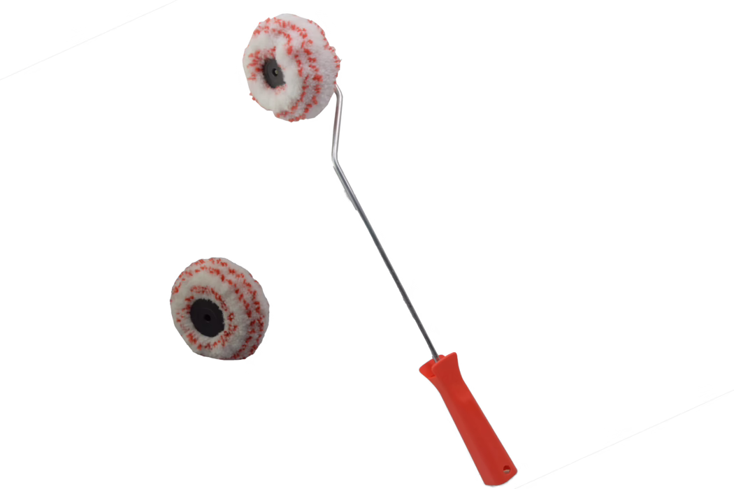 Mini-Farbroller mit rotem Plastikgriff und Metallbügel, bestückt mit einem weißen Rollbezug mit roten Sprenkeln; eine passende Ersatzrolle liegt daneben vor weißem Hintergrund.