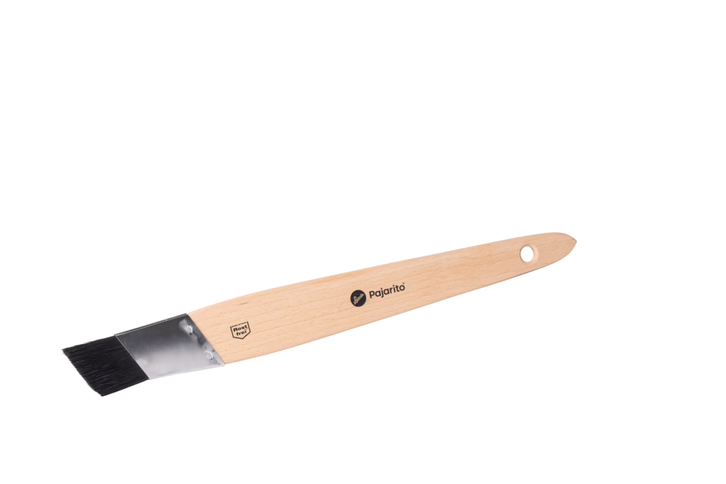 Ein flacher, abgeschrägter Malpinsel mit hellem Holzgriff, Metallzwinge und schwarzen synthetischen Borsten, vor weißem Hintergrund.