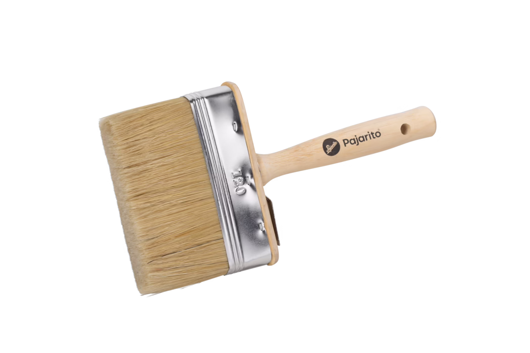 Ein breiter, flacher Malerpinsel auf weißem Hintergrund. Der Pinsel hat dichte, naturfarbene Borsten, eine Metallzwinge mit Prägung '120' und einen glatten, hellen Holzgriff mit Aufhängeloch. Auf dem Griff ist die Markenbezeichnung 'Pajarito' aufgedruckt. Das Bild zeigt den Pinsel diagonal liegend mit den Borsten links und betont die Struktur der Borsten, die glänzende Metallzwinge und die Holzmaserung. Geeignet für Wandfarbe, Lacke und breite Pinselstriche; sauberes, unbenutztes Produkt, ideal für Produktfotos oder Kataloge.