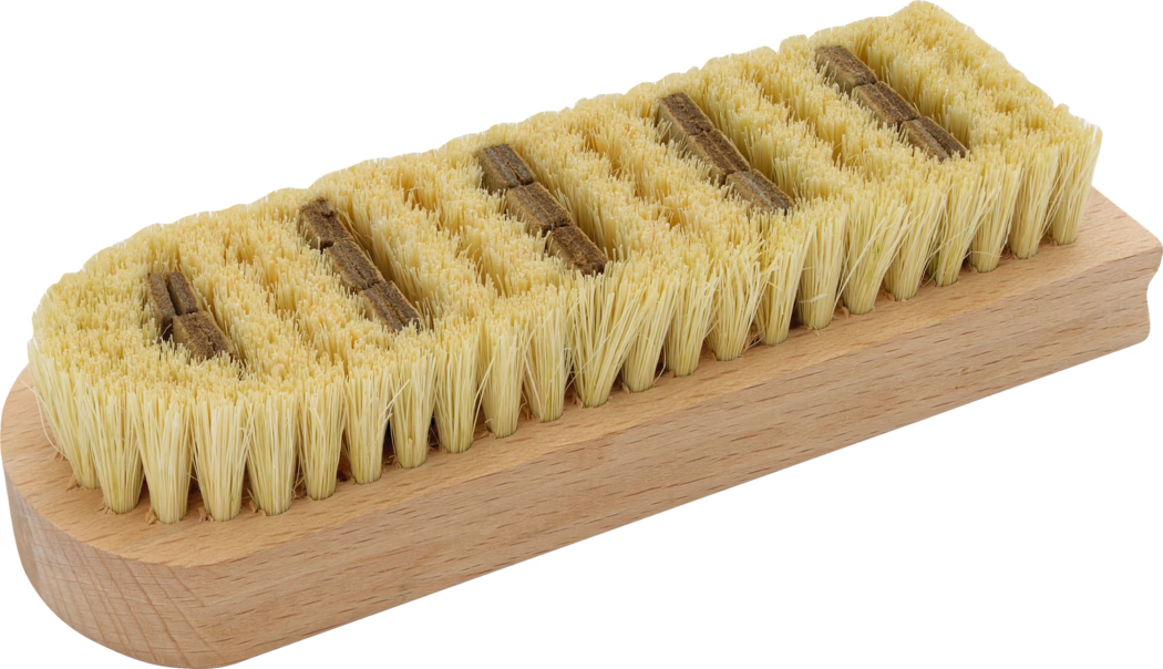 Pajarito_Dummy_Smoothing brush fibre bristle_014359_2021-02 Nahaufnahme einer rechteckigen Holzschrubbbürste mit dicht stehenden gelblichen Naturborsten, in mehreren Reihen auf einem glatten, hellen Holzblock angeordnet; zwischen den Reihen sind kleine braune Einsätze sichtbar; dient zum Reinigen und Schrubben von Oberflächen; fotografiert auf weißem Hintergrund.