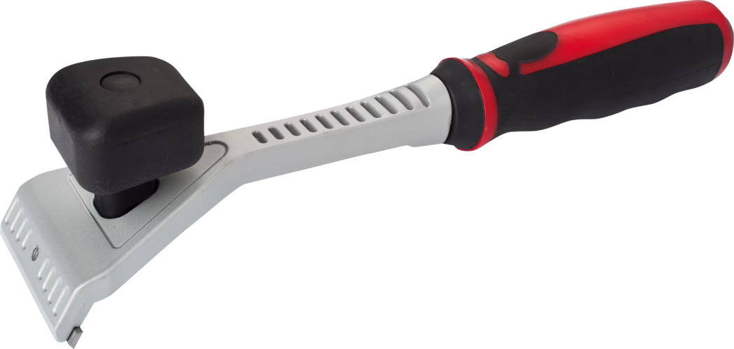 Handheld scraper tool with an angled silver metal head featuring a small replaceable metal blade at the front edge for scraping paint, adhesive or grout. A black, square rubber block mounted on a short post sits on top of the head, providing a cushioned striking surface or protective bumper. The metal shaft has a series of vent-like cutouts and joins a long ergonomic handle finished in black and red soft-grip rubber with molded contours for a secure, comfortable grip. The tool appears sturdy and versatile for light demolition, scraping and controlled tapping tasks in renovation or finishing work.