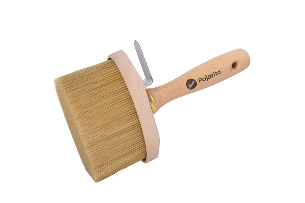 Pajarito_Dummy_Paintbrush Nature Mix oval E-Line_179056_2024-02 Ein runder Flächenstreicher mit kurzem, ergonomischem Holzgriff der Marke „Pajarito“. Er besitzt einen breiten, zylindrischen Bürstenkopf mit dicht angeordneten hellbeigen Borsten, einen ringförmigen Holzkragen und eine kleine Metallklammer zum Aufhängen oder als Stütze. Der Griff besteht aus hellem Buchenholz, ist fein geschliffen, verfügt über ein Aufhänge-Loch und das aufgedruckte „Pajarito“-Logo. Die Borsten sind gerade geschnitten und eignen sich zum gleichmäßigen Auftragen von Farbe, Lasur oder Klebstoff auf großen Flächen. Die Aufnahme zeigt das Objekt vor weißem Hintergrund mit klarer Darstellung der Holzstruktur und Borstentextur.