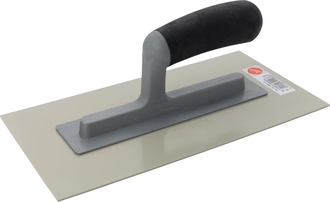 Pajarito_Dummy_Plastic smoothing trowel hard_021758_2021-02 Eine Glättkelle mit rechteckiger beigefarbener Metallklinge und grauem Griff mit schwarzem gepolstertem Handstück, fotografiert vor weißem Hintergrund. Auf dem Griff ist die Prägung 'Made in Germany' zu sehen, auf der Klinge ein kleiner Barcode-Aufkleber.