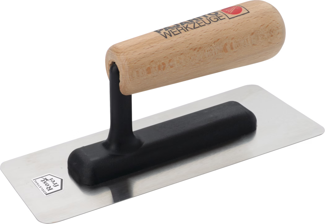 Pajarito_Dummy_Marble effect trowel wooden handle_013668_013669_013670_2021-03 Detailaufnahme einer rechteckigen Glättekelle mit polierter Edelstahlplatte und leicht abgerundeten Ecken. Sie verfügt über eine schwarze, geformte Kunststoffauflage und einen vertikalen Stiel, der einen glatten, abgerundeten Holzgriff mit natürlicher Oberfläche und aufgedrucktem Markenlogo trägt. Das Werkzeug ist sauber und vor weißem Hintergrund fotografiert und dient zum Glätten von Putz, Mörtel oder Verputz an Wänden und Decken. Deutlich zu erkennen sind die reflektierende Metallfläche, die schwarze, dämpfende Basis und die Holzmaserung des Griffes.